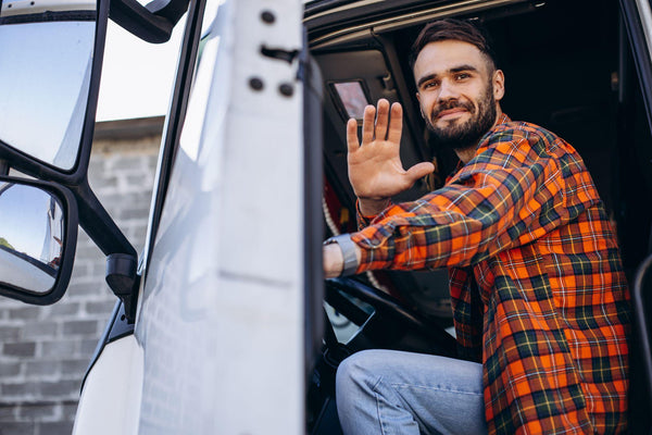 A happy truck driver waving at the camera