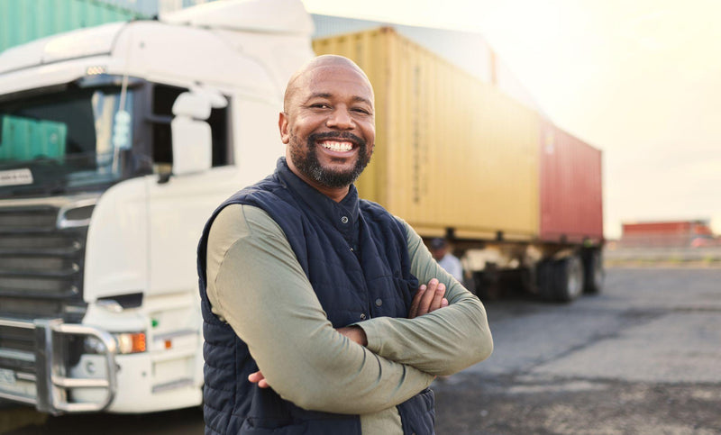 happy truck driver moving industry cargo and freight at a shipping supply chain or warehouse.