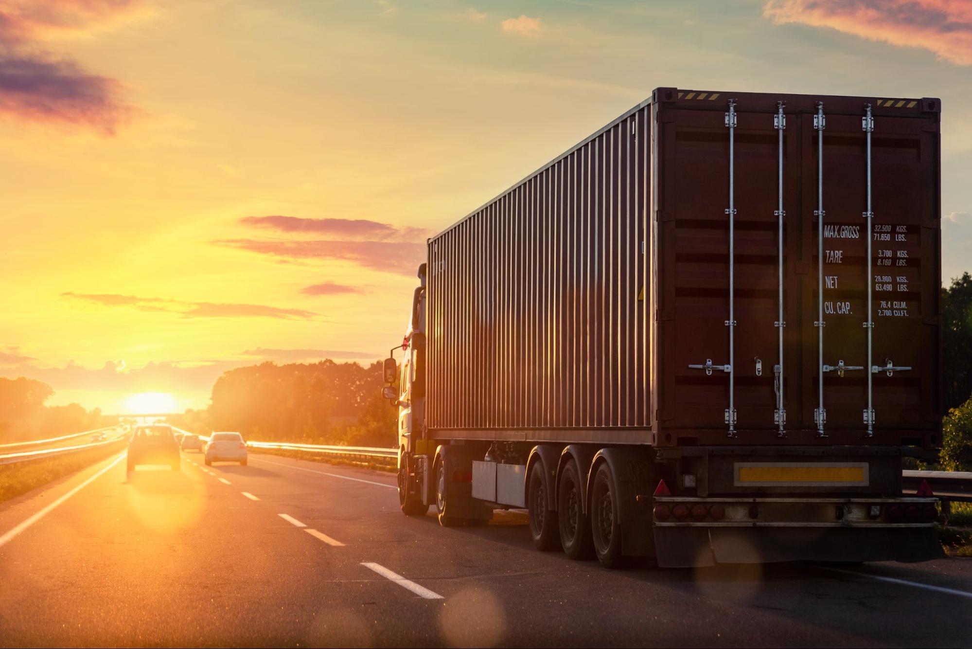 A truck driver driving towards the summer sun