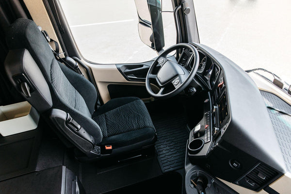 inside interior of big rig semi truck, clean with beige and black details 