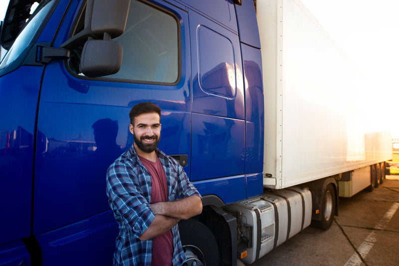 Semi truck driver leaning against his semi truck, proud of his customized semi truck seat inside