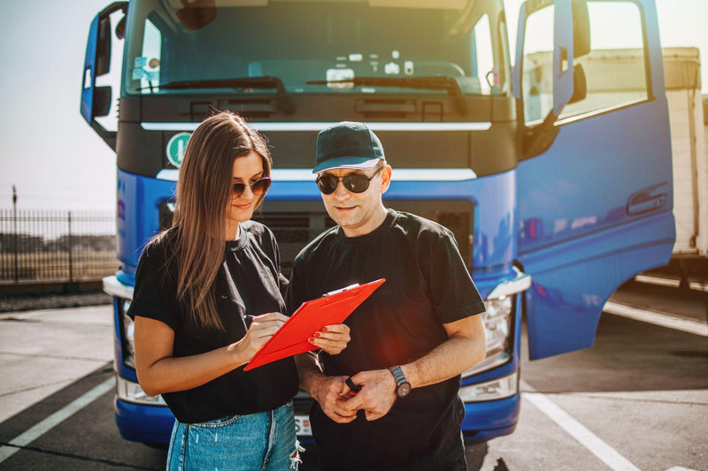Semi truck driver mentor giving instructions in front of a semi truck