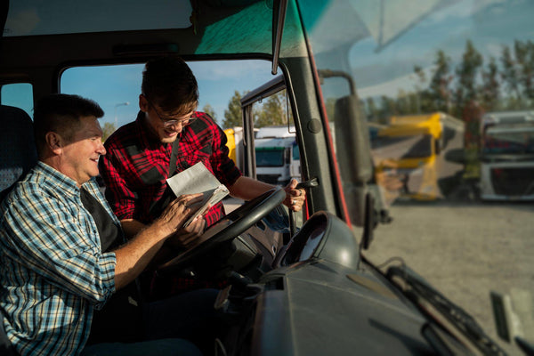 Semi truck fleet manager helping a driver plan his route