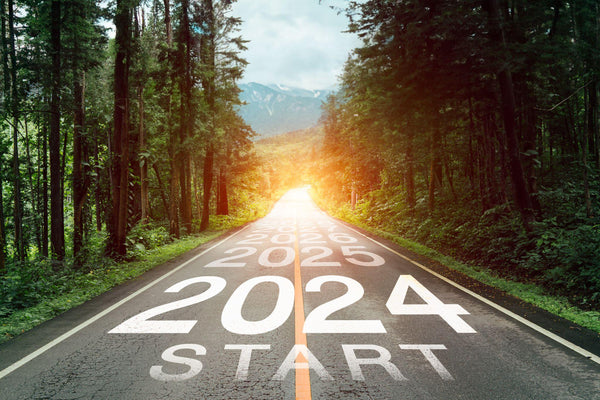 Text 2024 written on the middle of paved road with sunset.