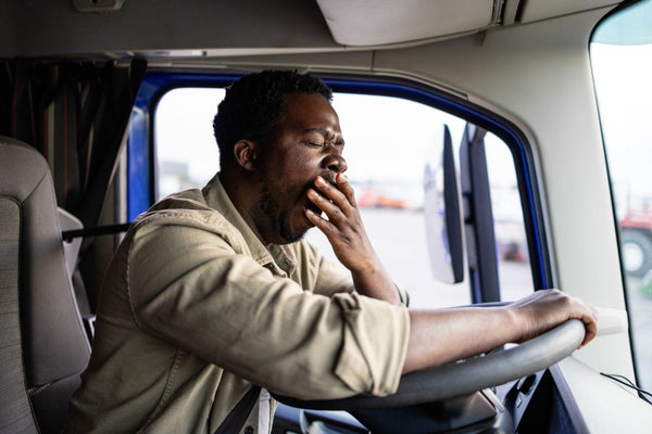 Tired truck driver potentially feeling the effects of highway hypnosis