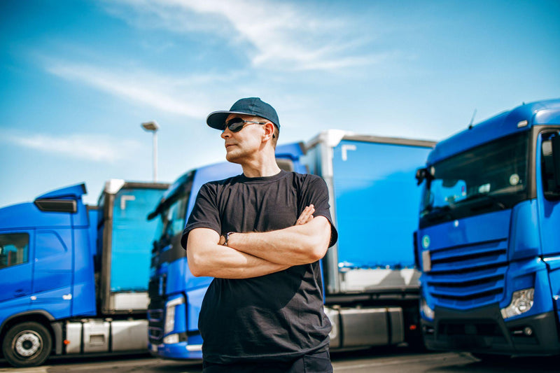 Truck driver standing in front of a truck fleet