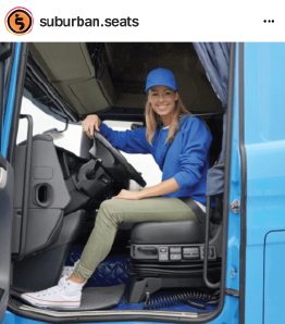  woman in blue shirt and hat driving truck 